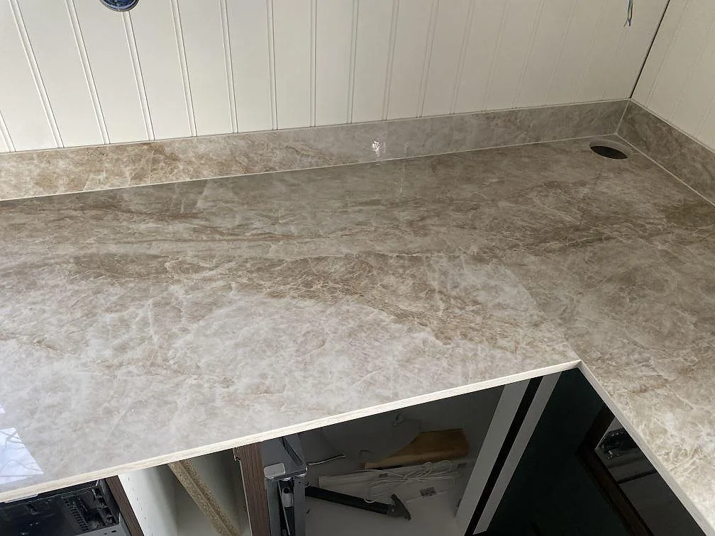 Närbild på polerad bänkskiva i Dekton Taga med rostfri diskho och blank reflektion i ett kök i Göteborg.