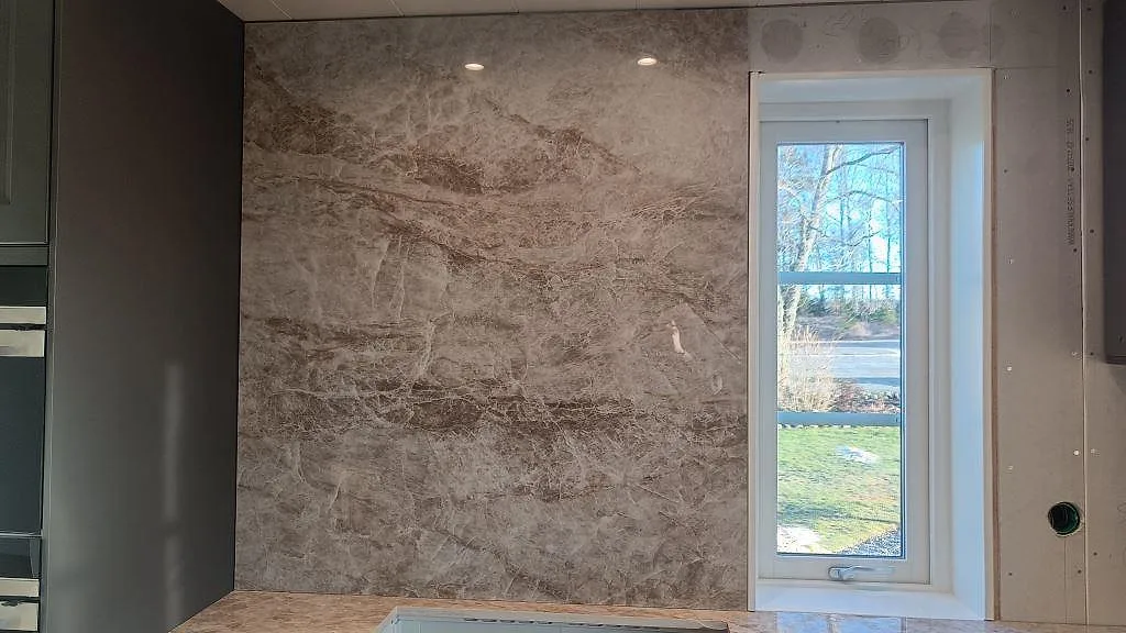 Heltäckande stänkvägg i Dekton Taga keramik med varm ådring bredvid ett fönster i ett kök i Grästorp.