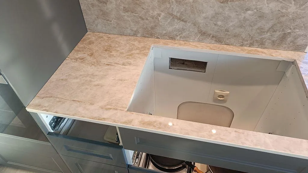 Ovanifrån av Dekton Taga köksbänkskiva i Grästorp med utskuren öppning för köksskåp under montering.