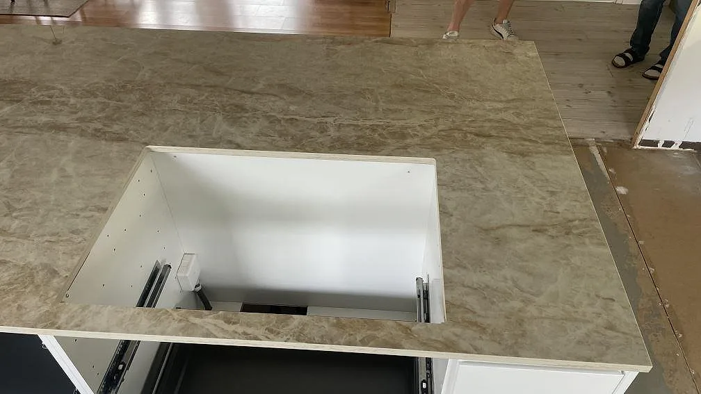 Detalj av polerad Dekton Taga som bred köksbänkskiva med öppet urtag för häll och tydlig ådring i Hässleholm.