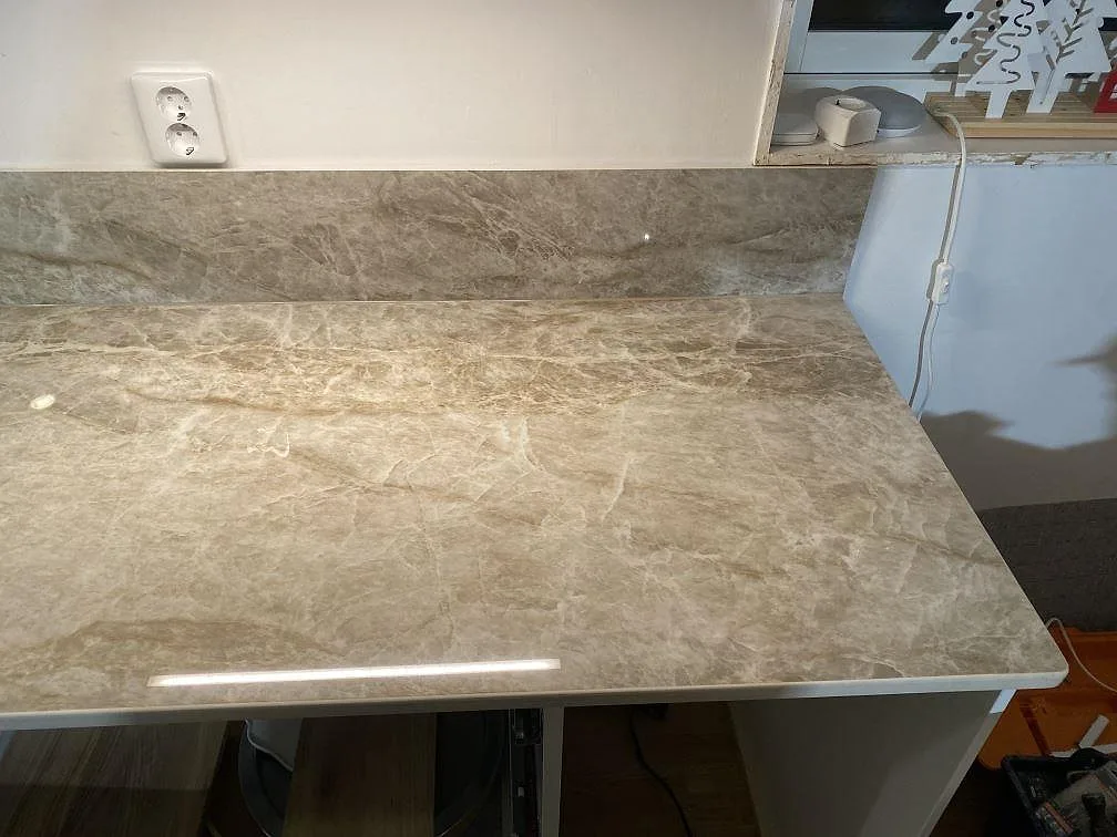 Sidobänk i polerad Dekton Taga med matchande stänkskydd och synlig gråbeige ådring i Hindås.