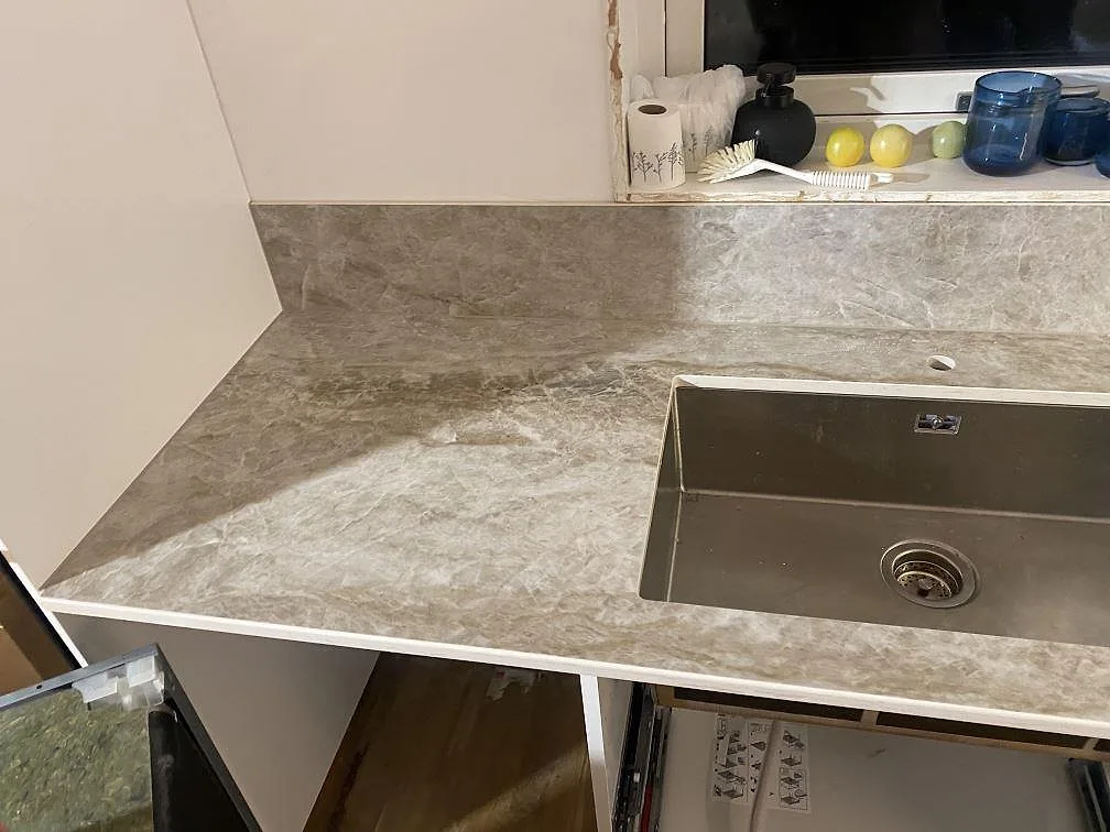 Diskbänk i polerad Dekton Taga med rostfri diskho, stänkskydd och ljusgrå ådring i Hindås.