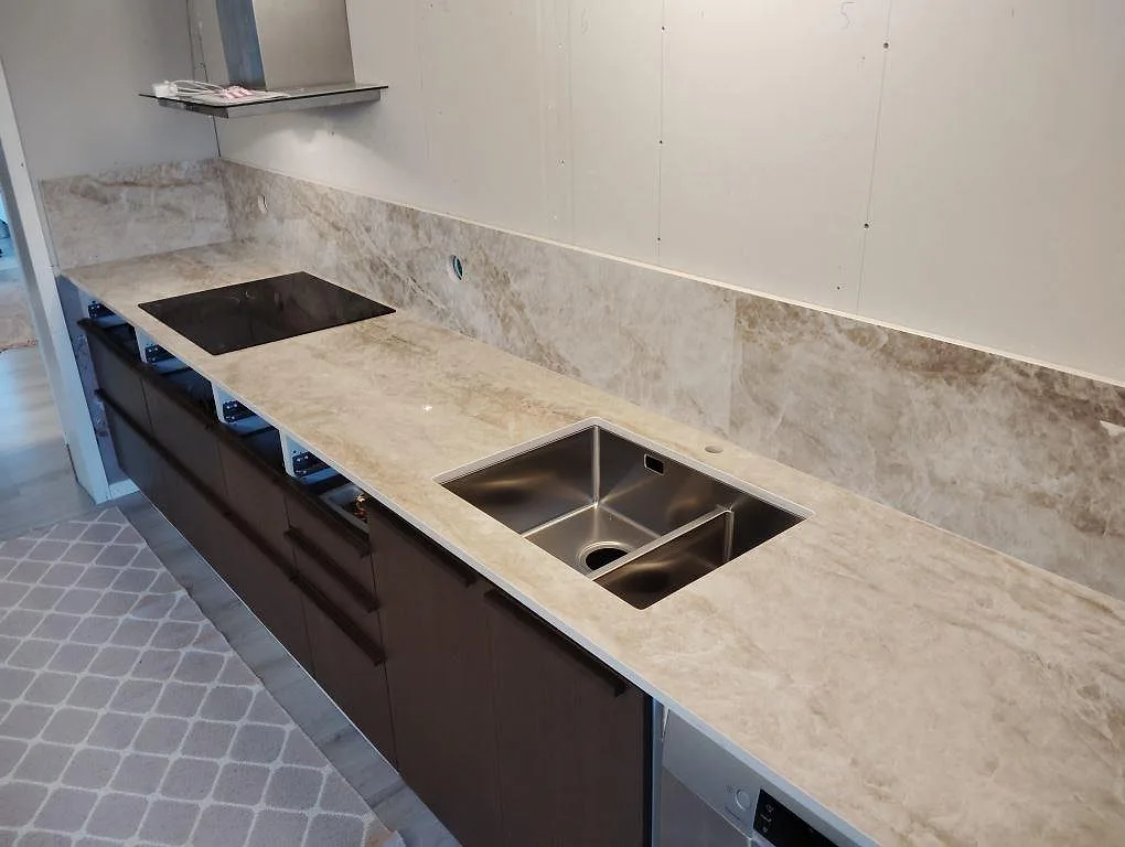 Polerad Dekton Taga köksbänkskiva med underlimmad rostfri diskho, induktionshäll och stänkskydd i samma keramik i Hudiksvall.