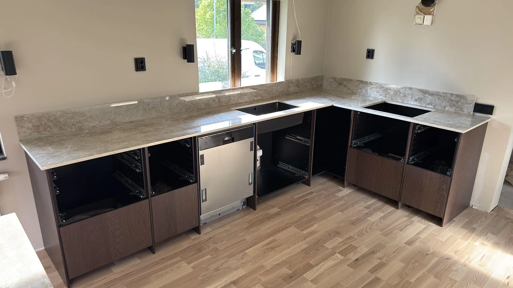 Köksbänkskiva i polerad Dekton Taga keramik med svart diskho och uppvikt stänkskydd i ett kök i Järfälla.