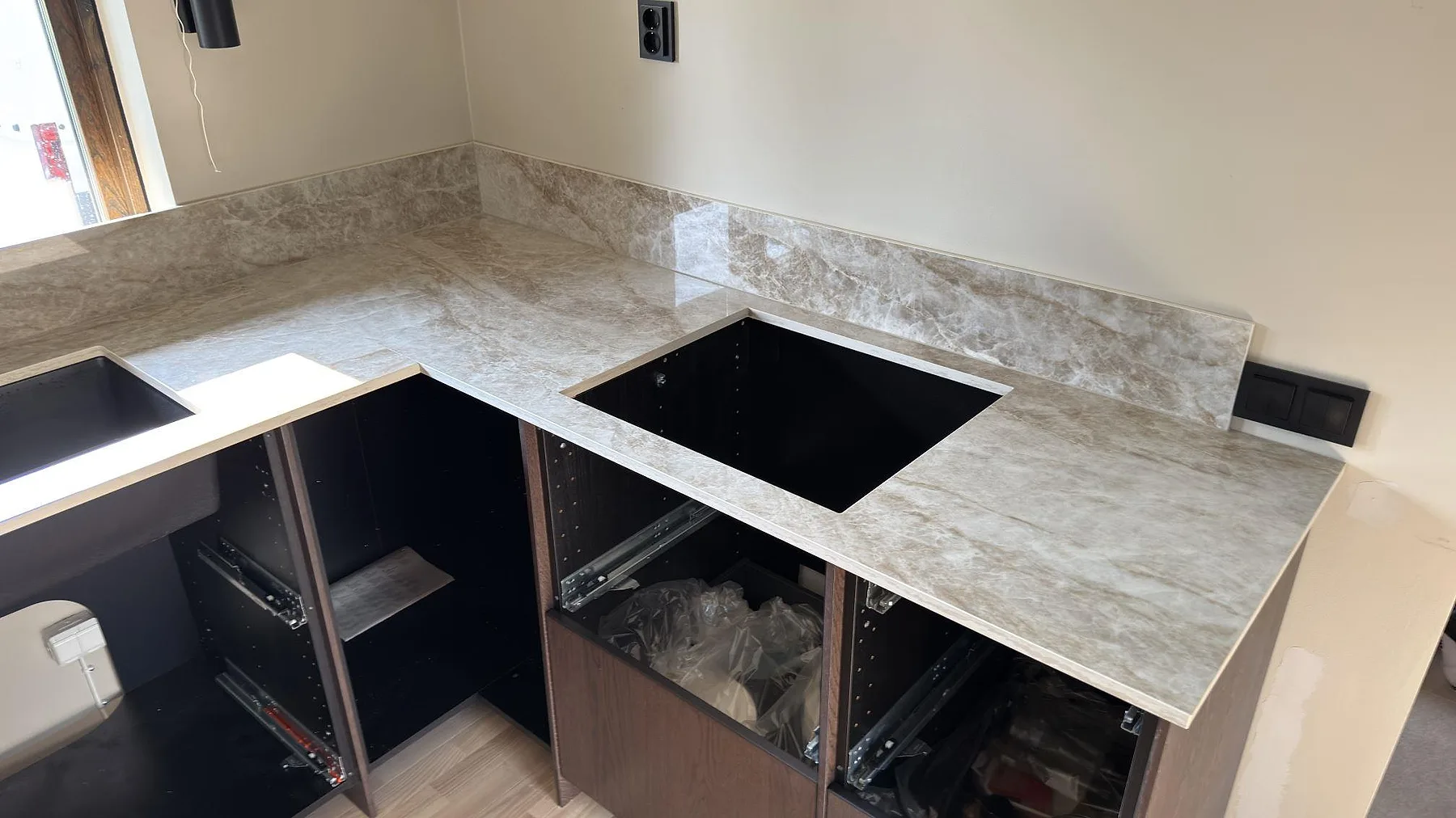 Polerad Dekton Taga bänkskiva i keramik med öppning för häll och matchande stänkskydd i kök i Järfälla.