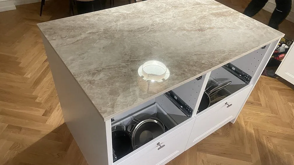 Köksbänkskiva på köksö i polerad Dekton Taga med öppen skåpstomme under montering i København Ø.