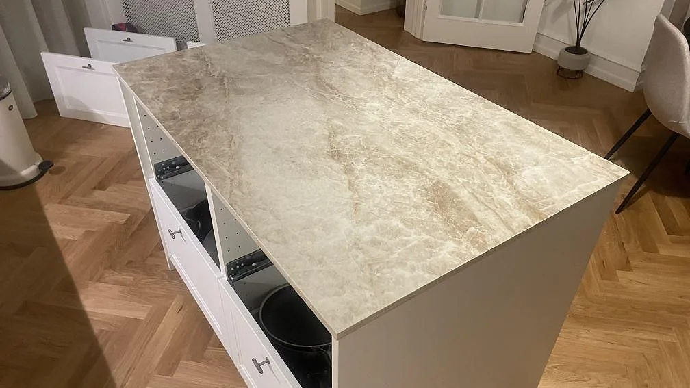 Närbild på köksö i polerad Dekton Taga, där den ljusgrå keramikens mönster syns över bänkskivan i København Ø.