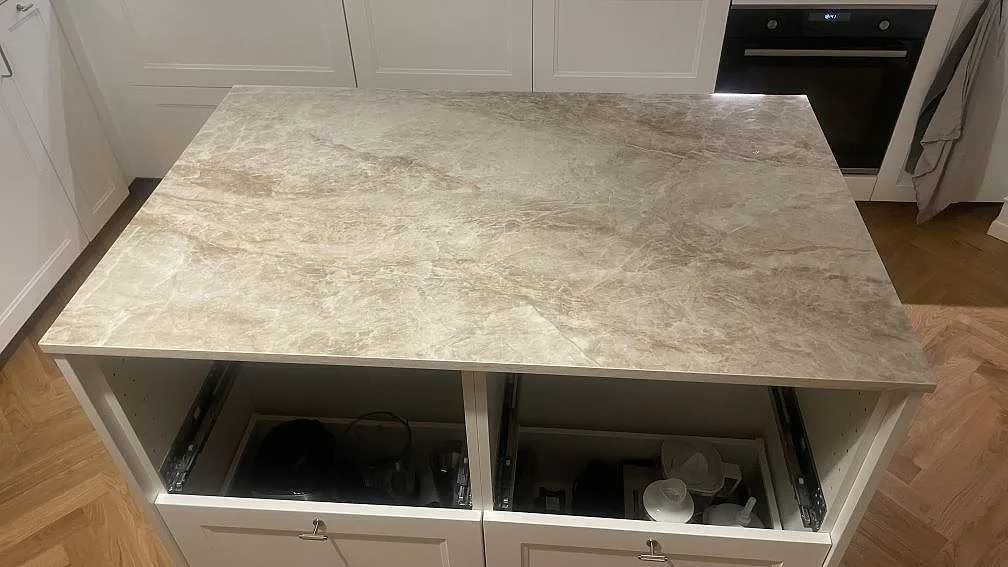 Rak köksö med keramikbänkskiva i 20 mm polerad Dekton Taga framför vita skåp i København Ø.