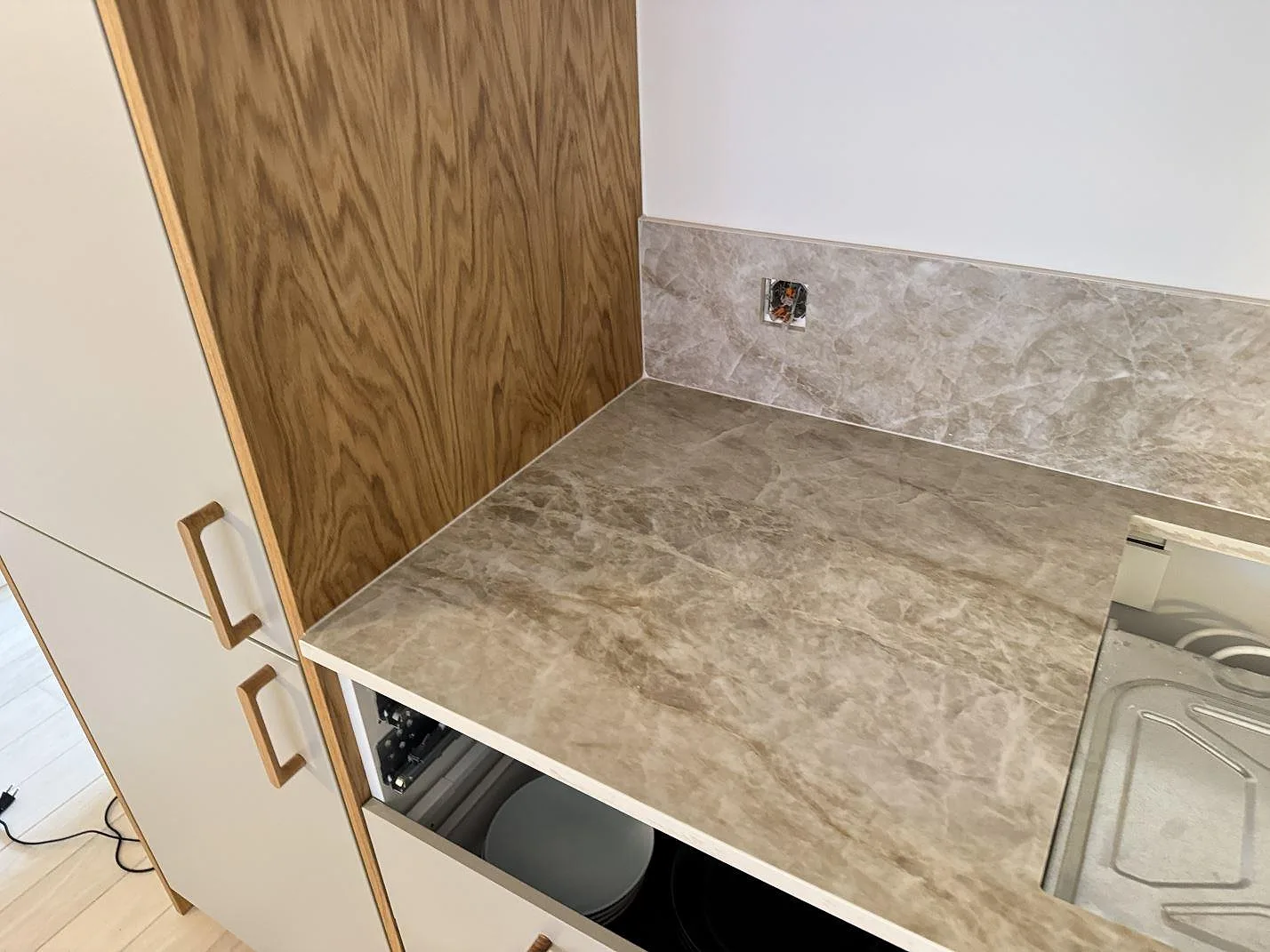 Närbild av polerad Dekton Taga, keramik, som köksbänkskiva med stänkskydd vid högskåp i Köpenhamn V.