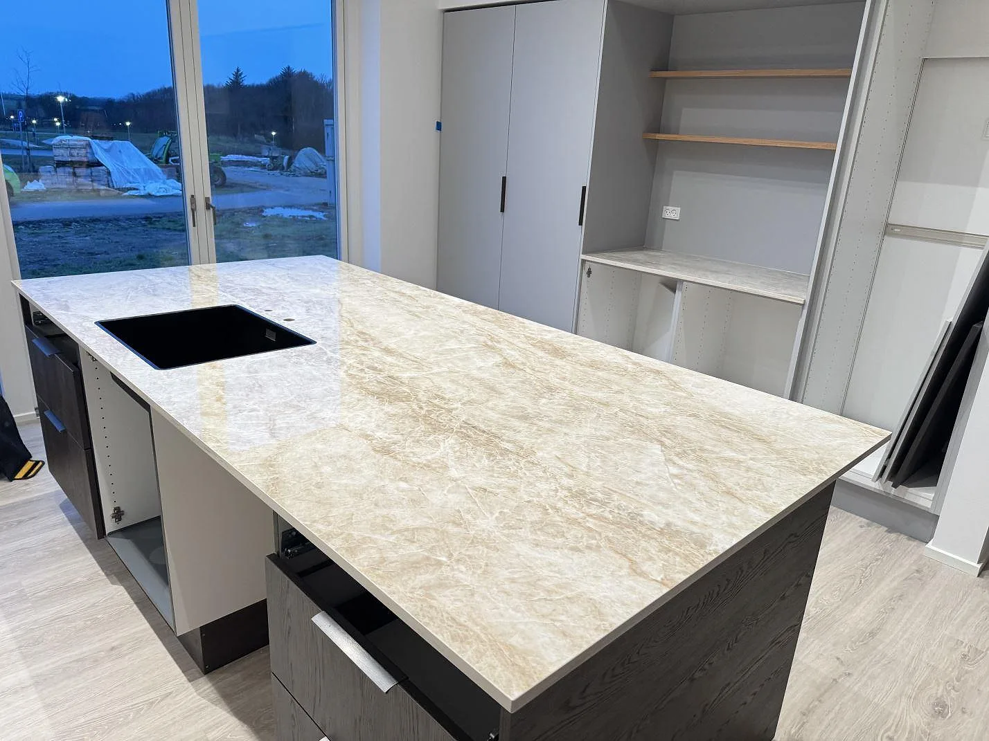 Köksö i Dekton Taga med varm beige ådring och svart underlimmad diskho, polerad keramikbänkskiva i ett kök i Thisted.