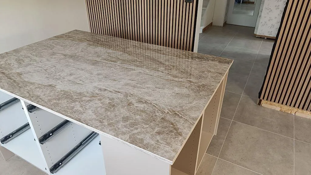 Köksö sedd från andra sidan med polerad Dekton Taga i keramik och öppna köksstommar i Trollhättan.