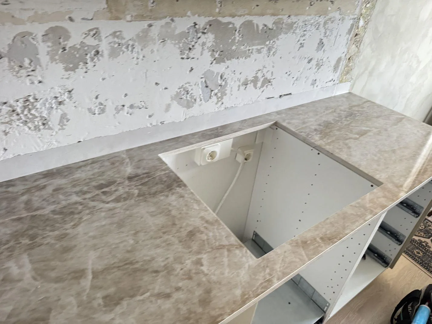 Dekton Taga som polerad keramikbänkskiva med öppet köksurtag och vita stommar under montering i Västra Frölunda.