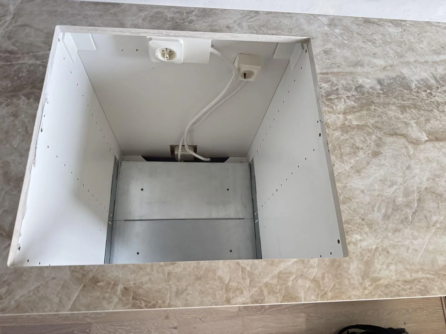 Närbild på öppet köksurtag i polerad Dekton Taga bänkskiva över vit stomme i Västra Frölunda.
