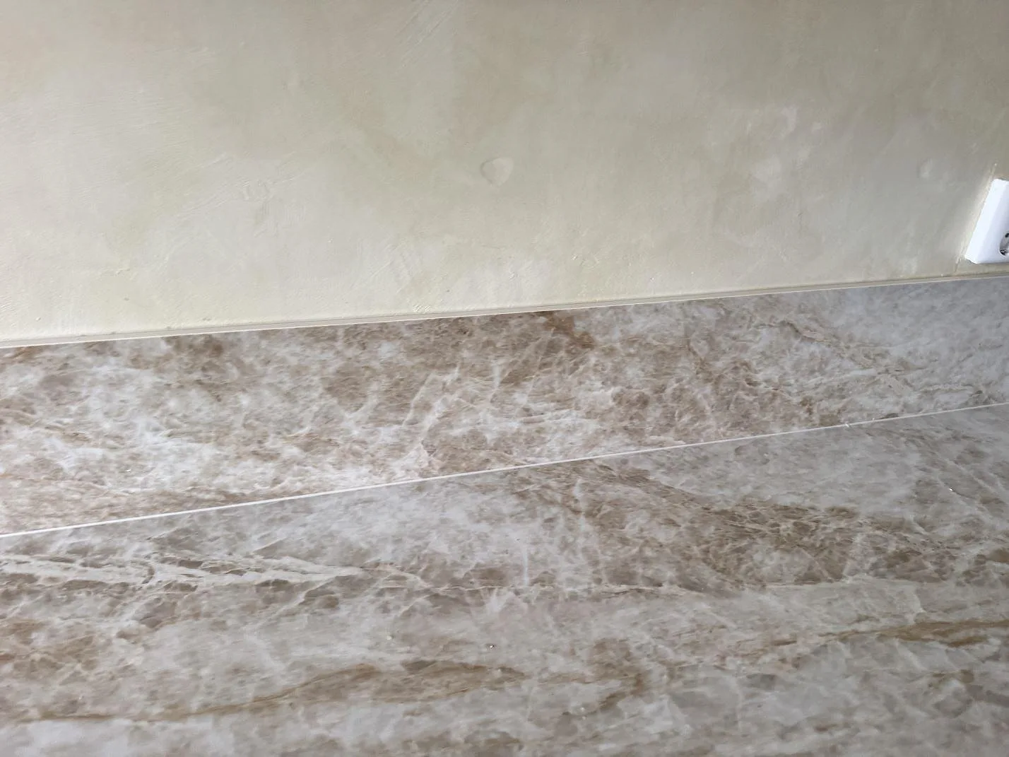 Närbild av stänkkant och arbetsyta i 12 mm polerad Dekton Taga keramik med ljus gråbeige stenlook i Västra Frölunda.