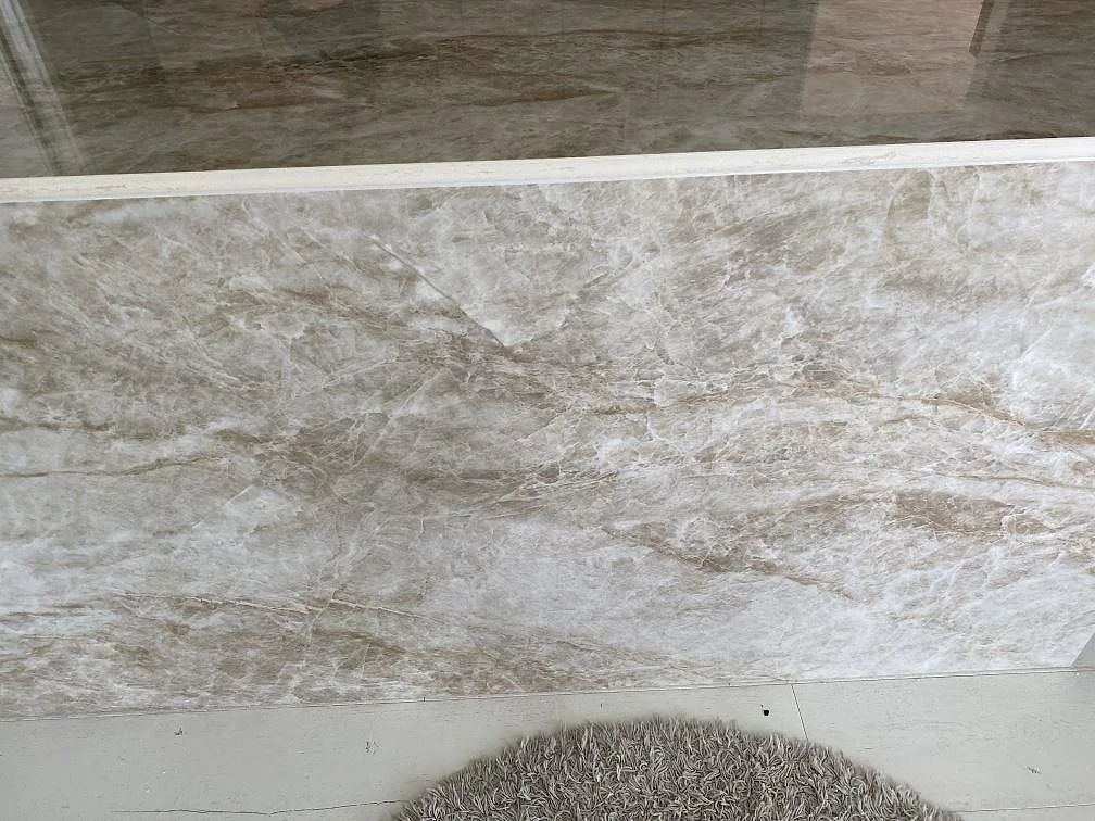 Köksö i polerad Dekton Taga med infälld induktionshäll och tydlig gyllenbrun ådring i ett kök i Växjö.