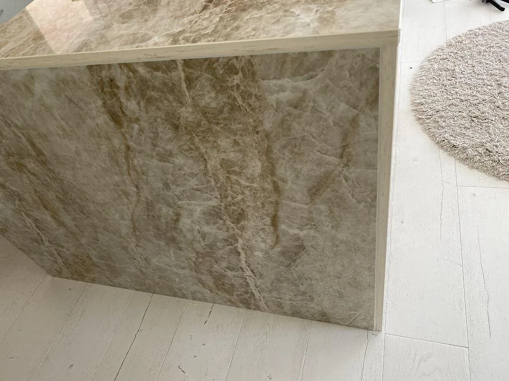 Bänkskiva och waterfall-sida i Dekton Taga, polerad greige keramik med fin ådring, i ett kök i Växjö.