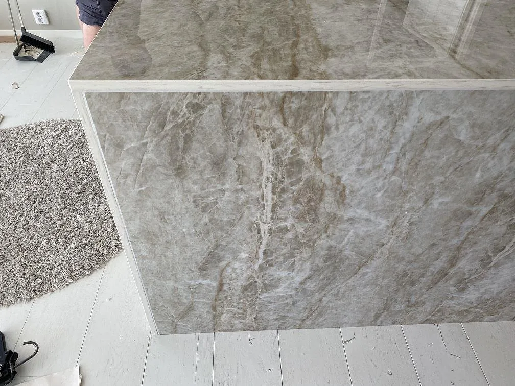 Gerat hörn på köksö i Dekton Taga keramik, polerad yta med spegelblank glans, i ett kök i Växjö.