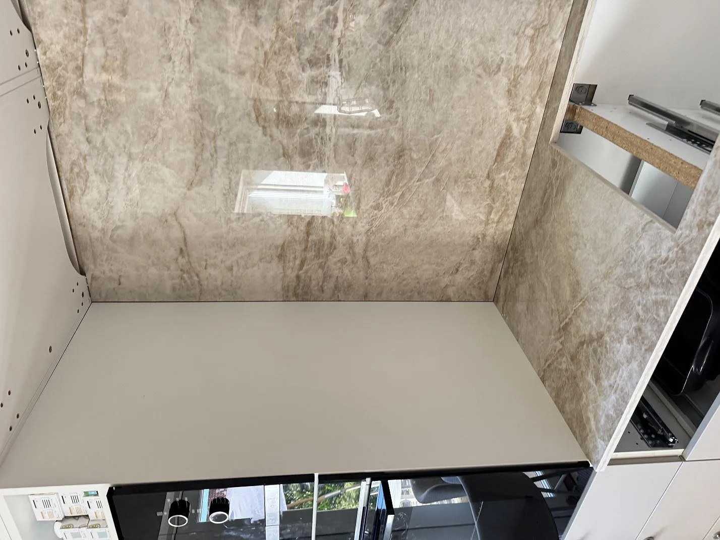 Matchande bänkskiva och väggskivor i polerad Dekton Taga keramik vid köksrad under montering i Virum.