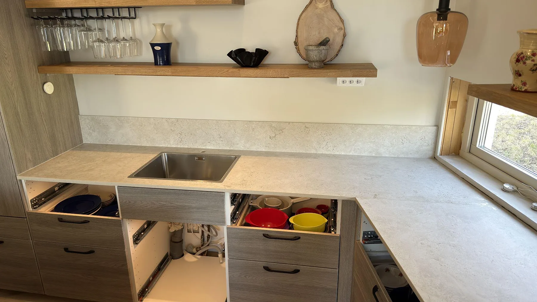 Väggbänk i matt Dekton TK05 Sabbia med underlimmad rostfri diskho och lågt stänkskydd i ett kök i Åkersberga.