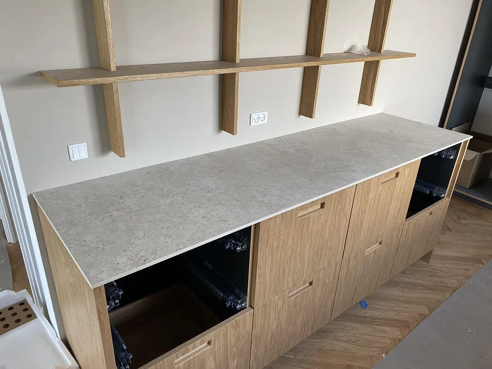 Matt köksbänkskiva i Dekton Tk05 Sabbia på låg skåprad med öppna stommar och trähylla i Birkerød.