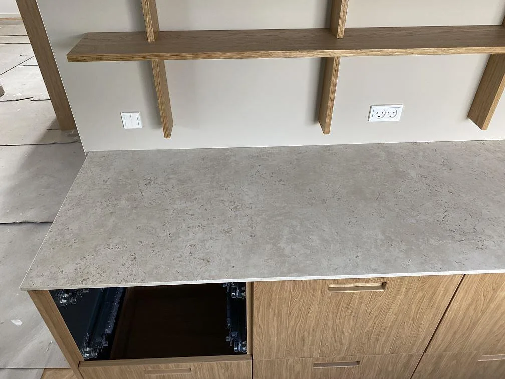 Närbild av matt Dekton Tk05 Sabbia som köksbänkskiva med ljus stenstruktur och träinredning i Birkerød.