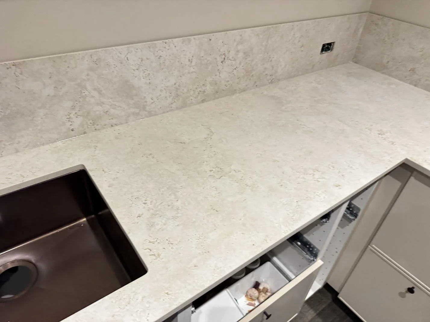 L-formad köksbänkskiva i matt keramik, Dekton Tk05 Sabbia, med diskho och lågt stänkskydd i Copenhagen.
