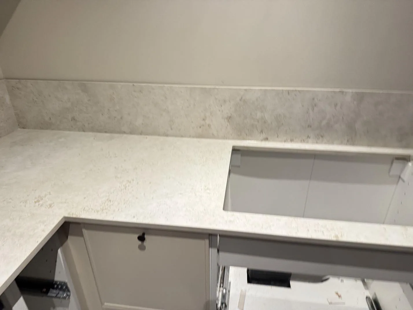 Matt keramisk köksbänkskiva i Dekton Tk05 Sabbia med stänkskydd och urtag över öppna stommar i Copenhagen.