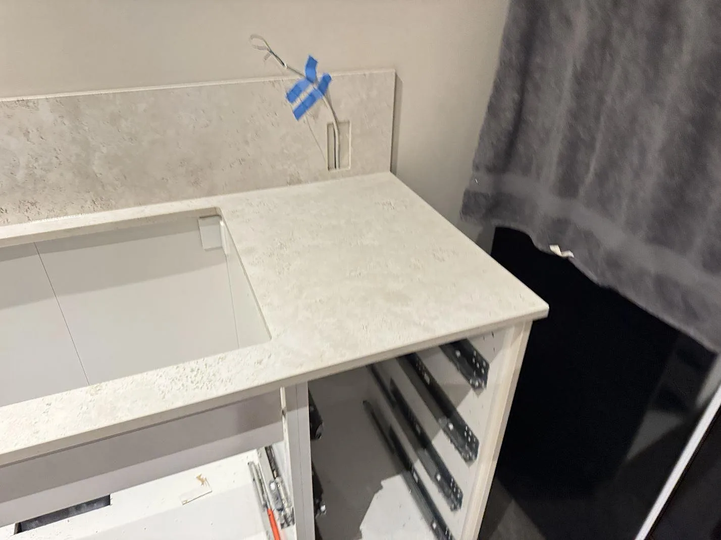 Kök under montering med matt Dekton Tk05 Sabbia i keramik, rektangulärt urtag och stänkskydd i Copenhagen.