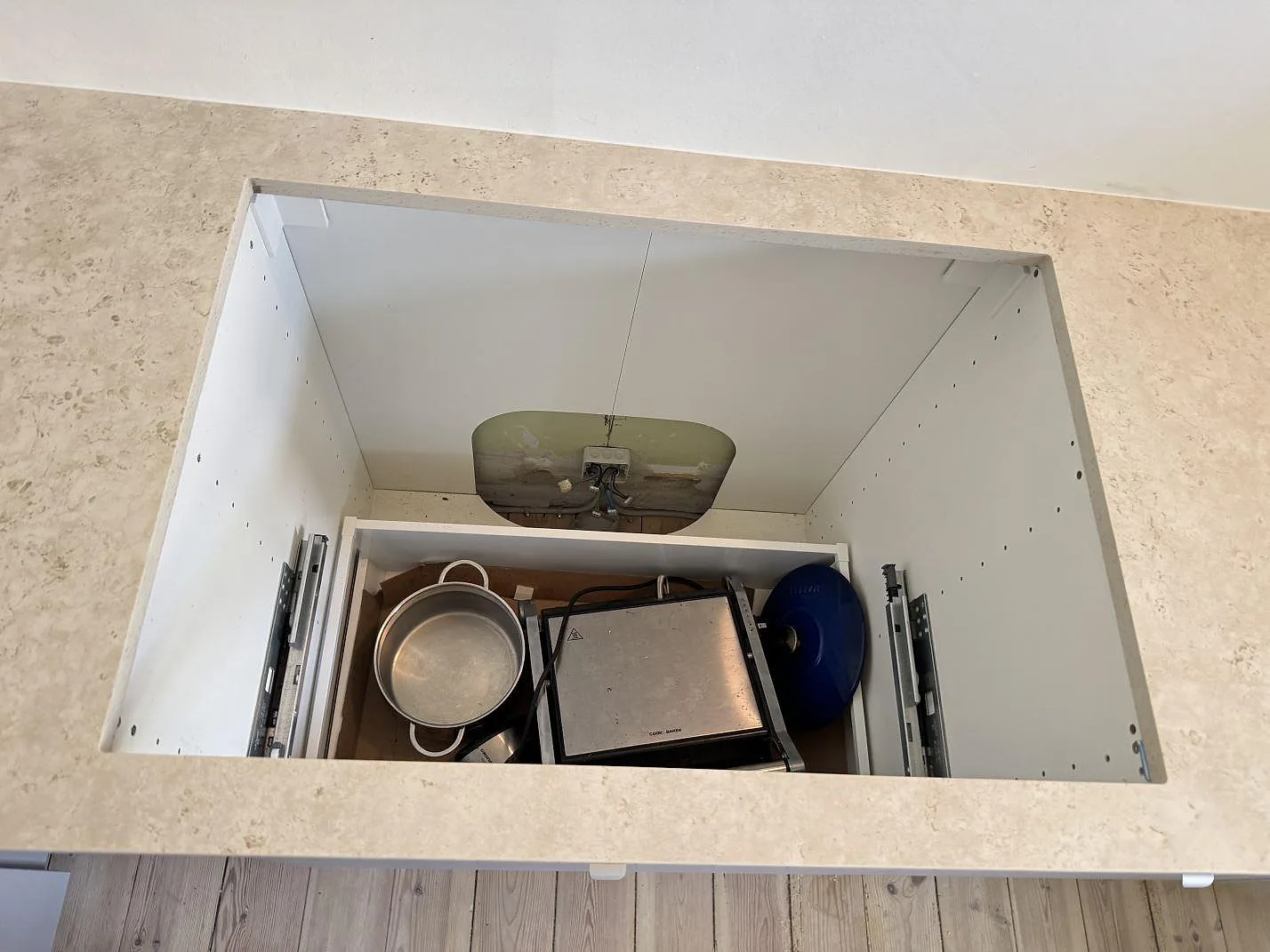 Öppet diskhoskåp under matt Dekton Tk05 Sabbia köksbänkskiva med rak urtagskant i Frederiksberg.