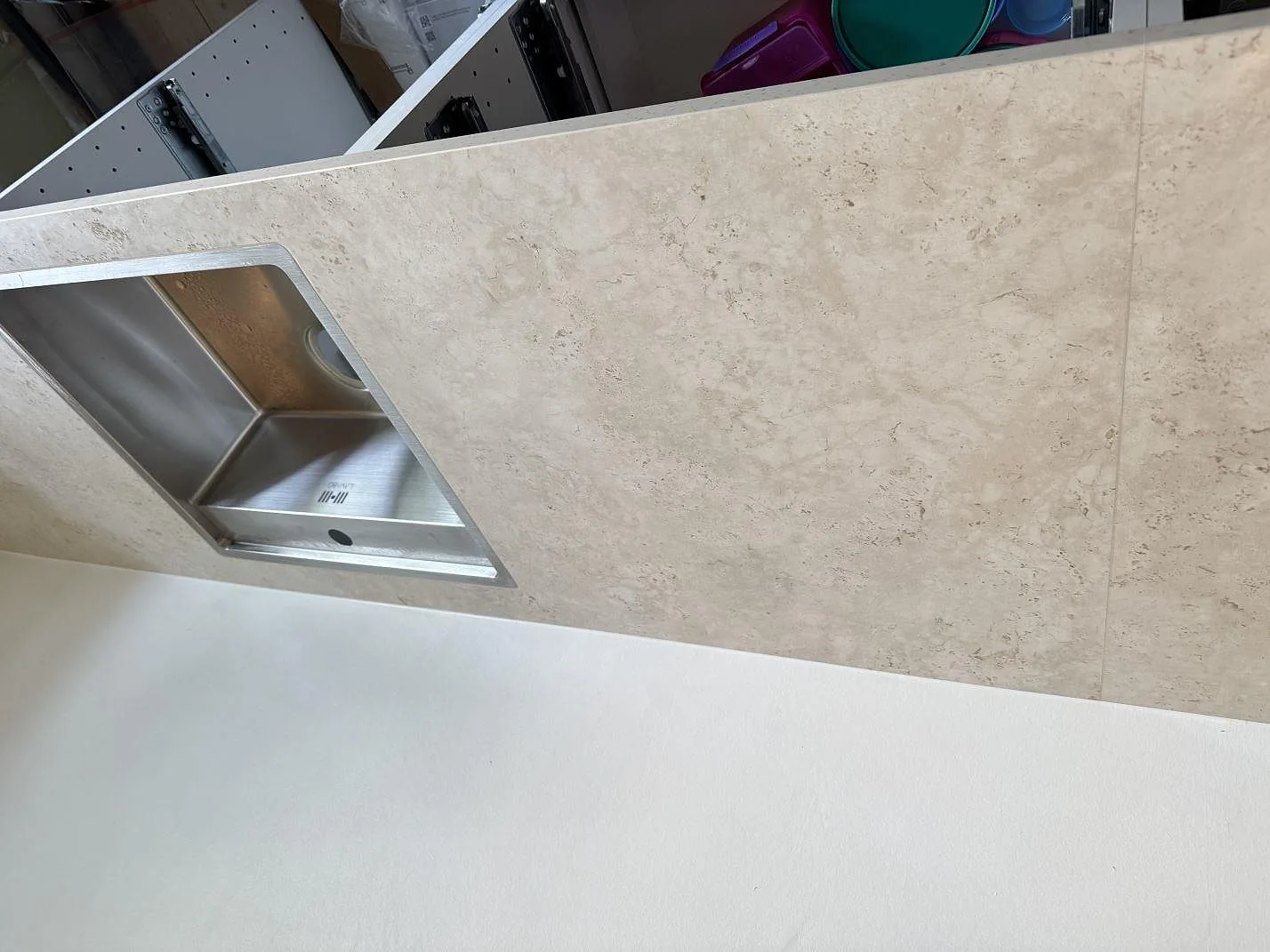 Installerad diskho och matt Dekton Tk05 Sabbia köksbänkskiva över öppna stommar i Frederiksberg.