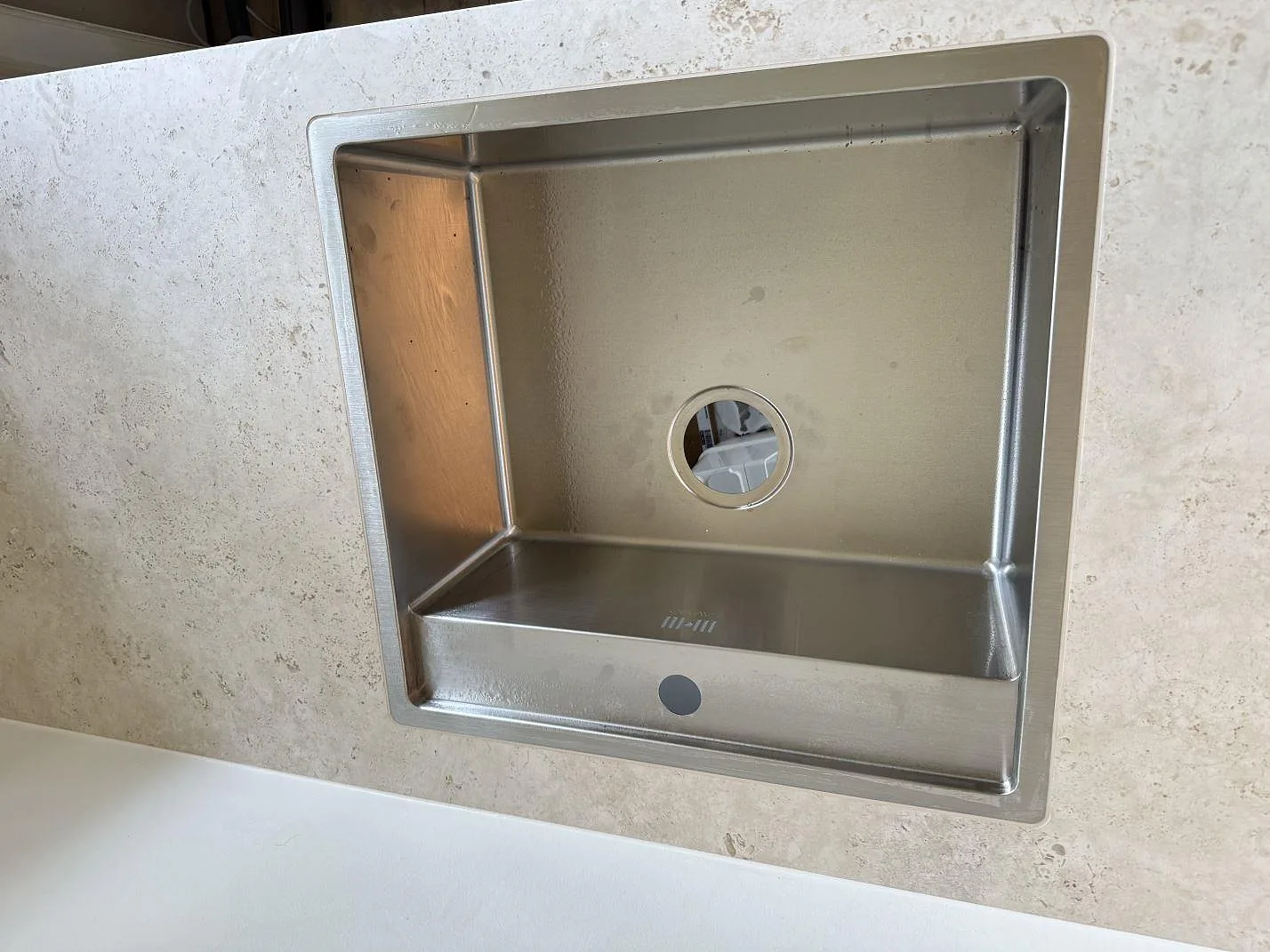 Rostfri diskho i en matt Dekton Tk05 Sabbia köksbänkskiva med ljus keramisk yta i Frederiksberg.