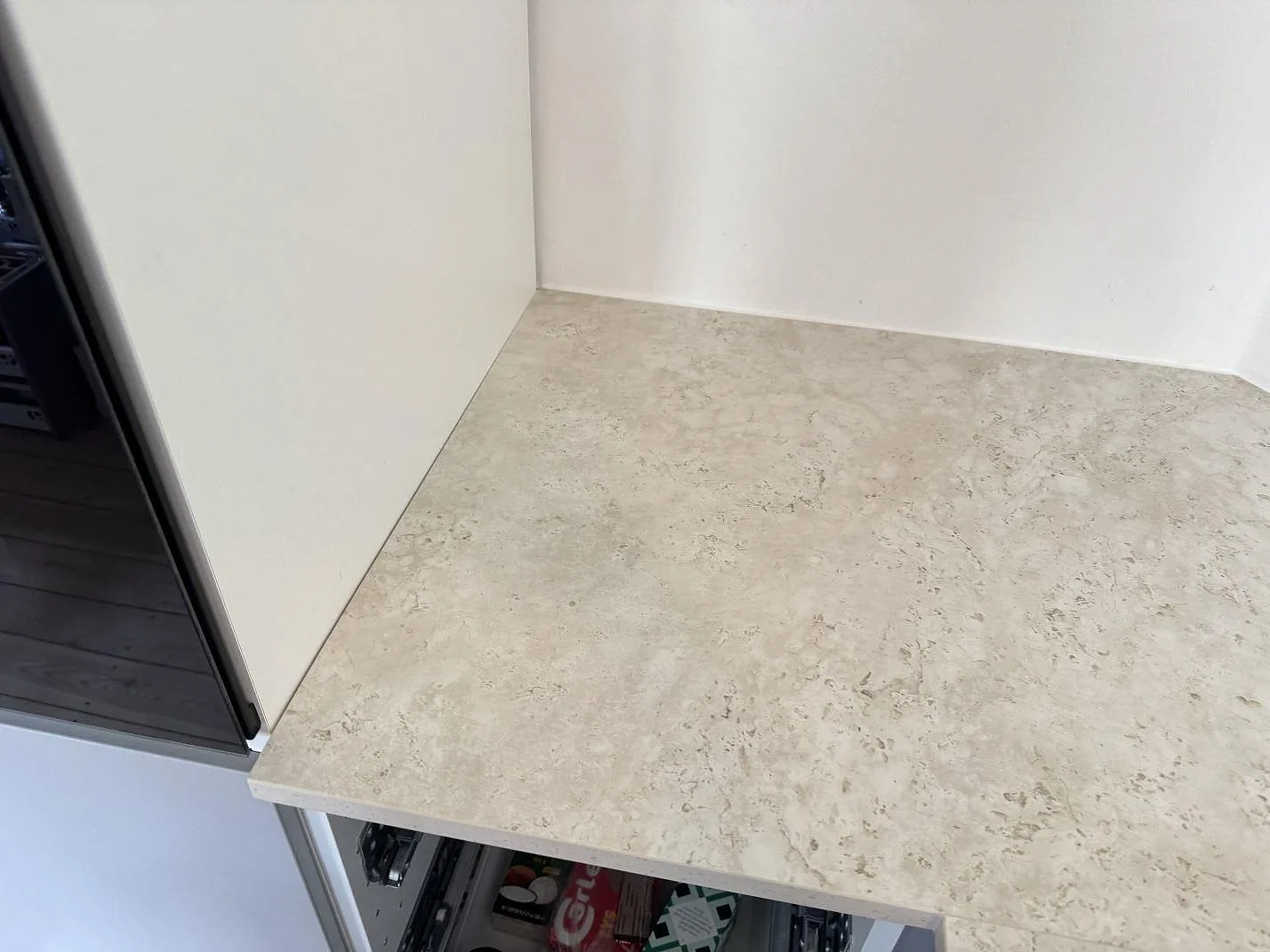 Närbild på matt köksbänkskiva i Dekton Tk05 Sabbia intill högskåp och vägg i Frederiksberg.