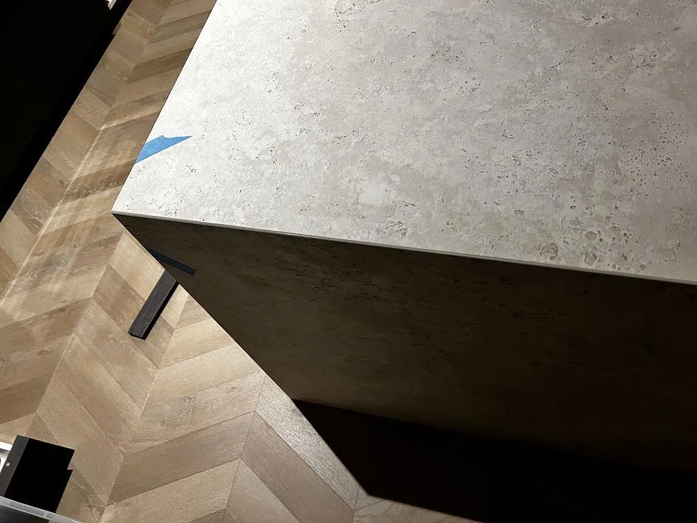 Detalj av köksöns kant i matt Dekton Tk05 Sabbia med blå monteringstejp och fiskbensparkett i Göteborg.