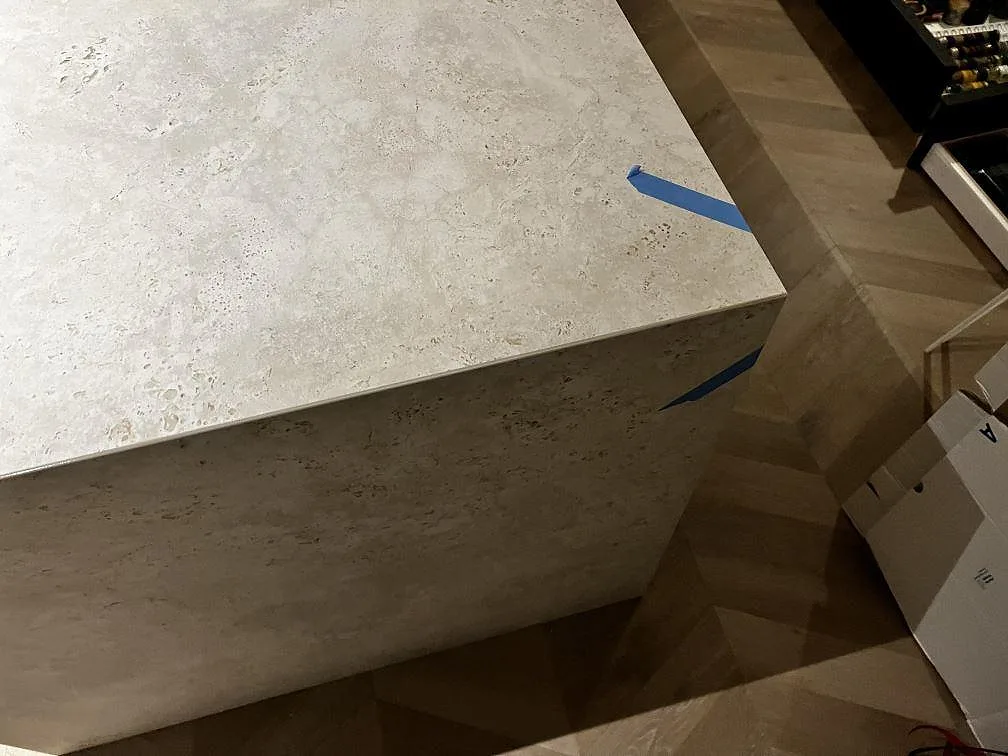 Närbild av köksö i matt Dekton Tk05 Sabbia med tjock kant och blå monteringstejp i Göteborg.