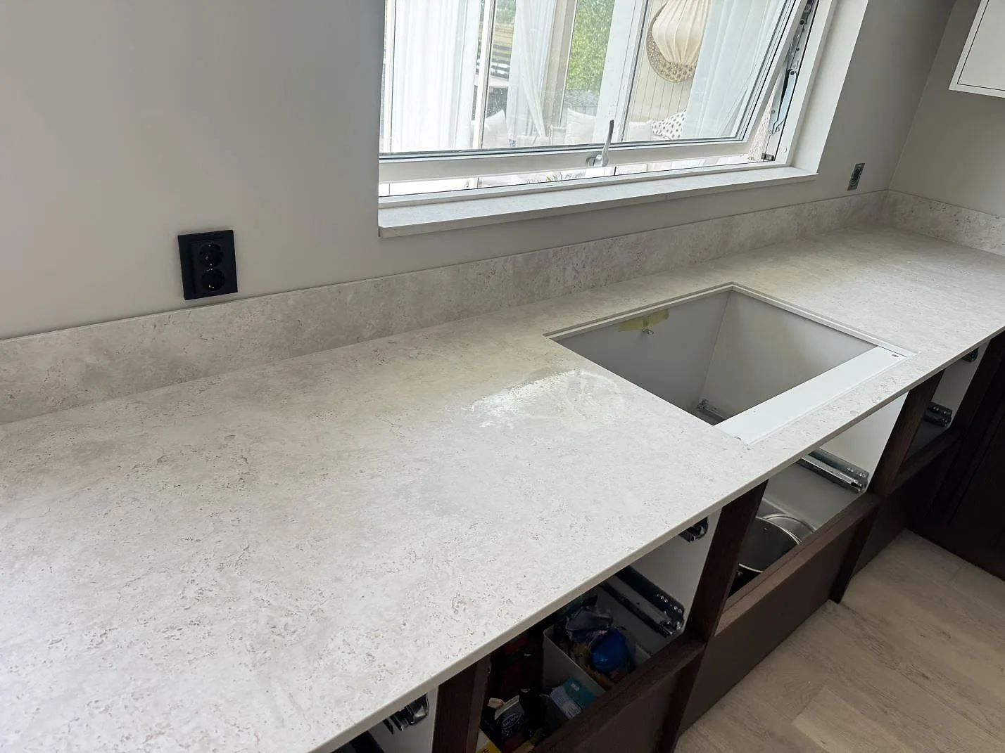 Köksbänkskiva i matt Dekton Tk05 Sabbia med 8 mm stänkskydd och diskhoöppning i ett kök i Lindome.