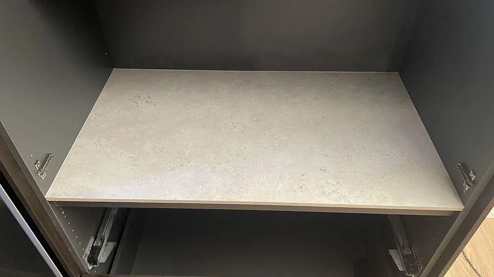 Installerad skivdel i matt Dekton Tk05 Sabbia i mörkt köksskåp i Lomma.