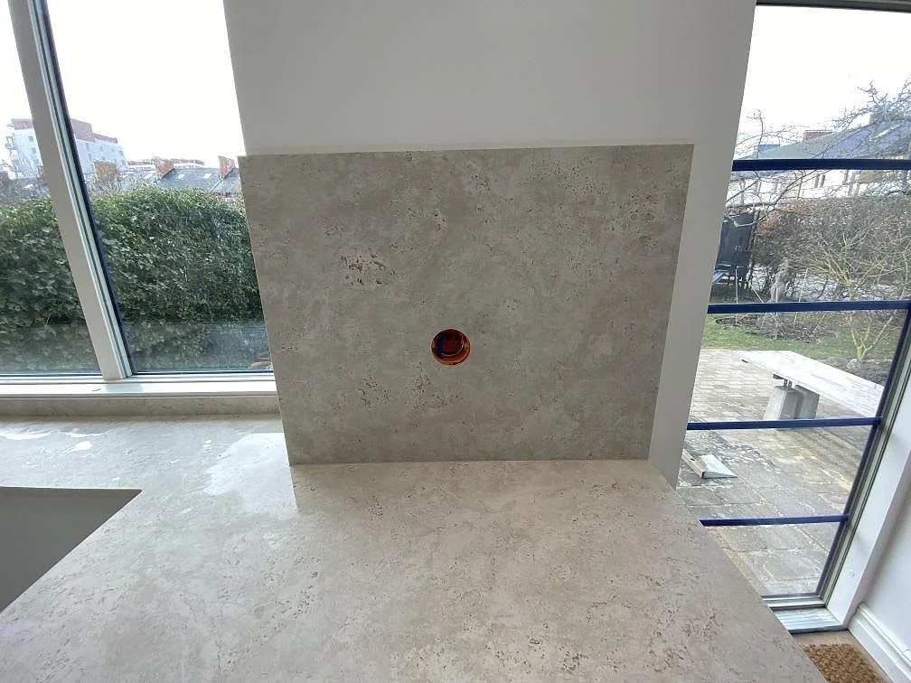 Närbild på 8 mm stänkskydd i matt Dekton Tk05 Sabbia över köksbänkskiva vid fönster i Malmö.