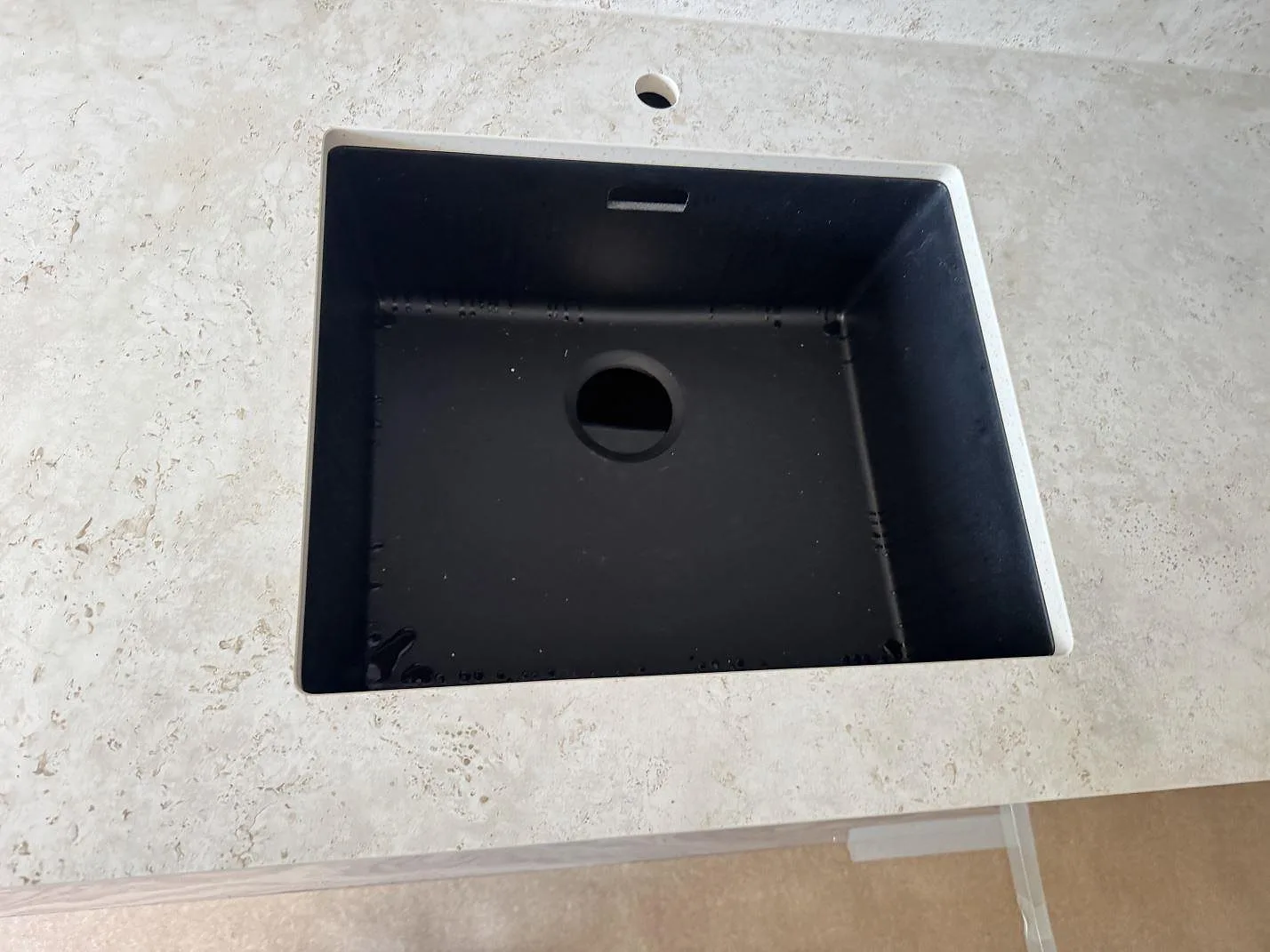 Närbild på svart underlimmad diskho i matt Dekton Tk05 Sabbia med sandbeige keramisk struktur i Malmö.