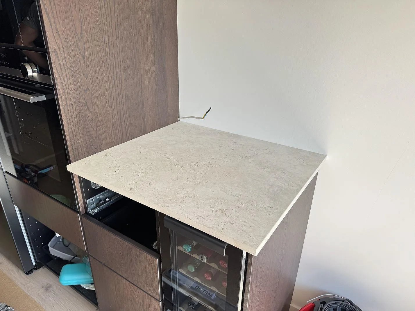 Sidobänk i matt Dekton Tk05 Sabbia, keramik, monterad intill mörk träinredning i ett kök i Malmö.