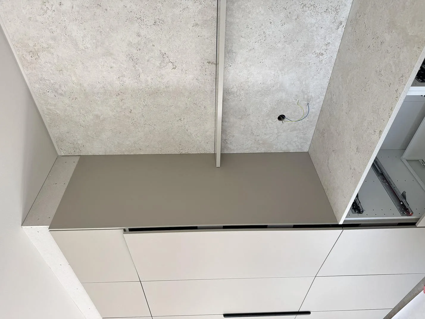 Matt Dekton Tk05 Sabbia som köksbänkskiva och väggbeklädnad med hällzon i ett kök i Oxie.