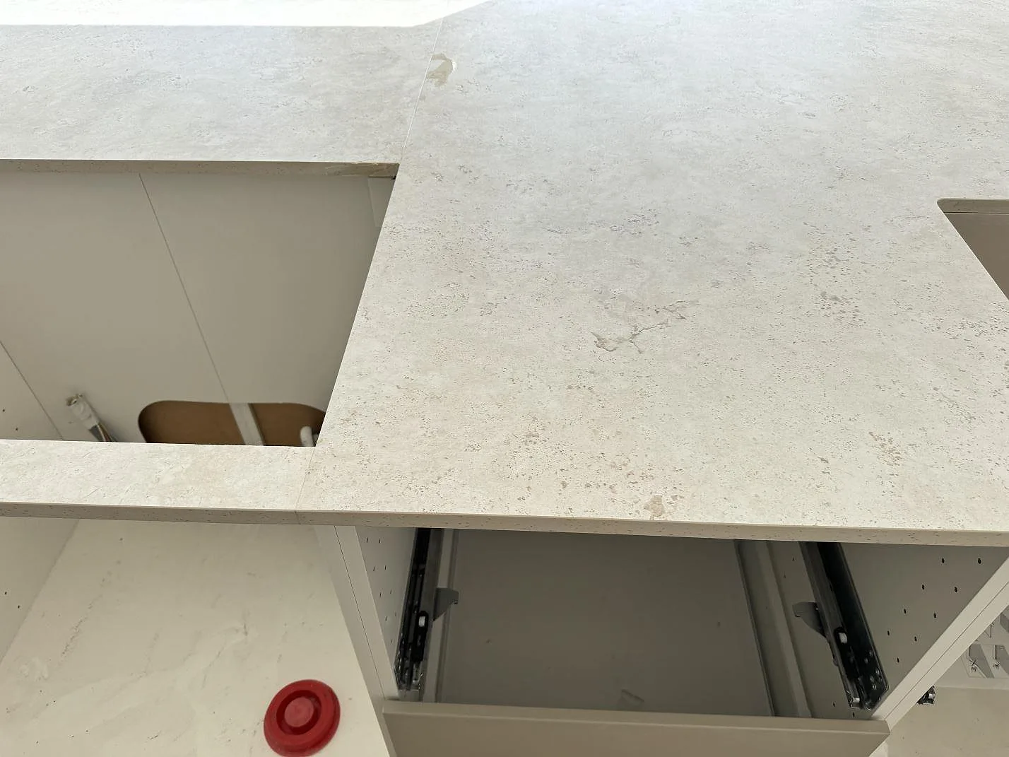 Köksbänkskiva i matt Dekton Tk05 Sabbia med öppningar för diskho och häll under montering i Oxie.