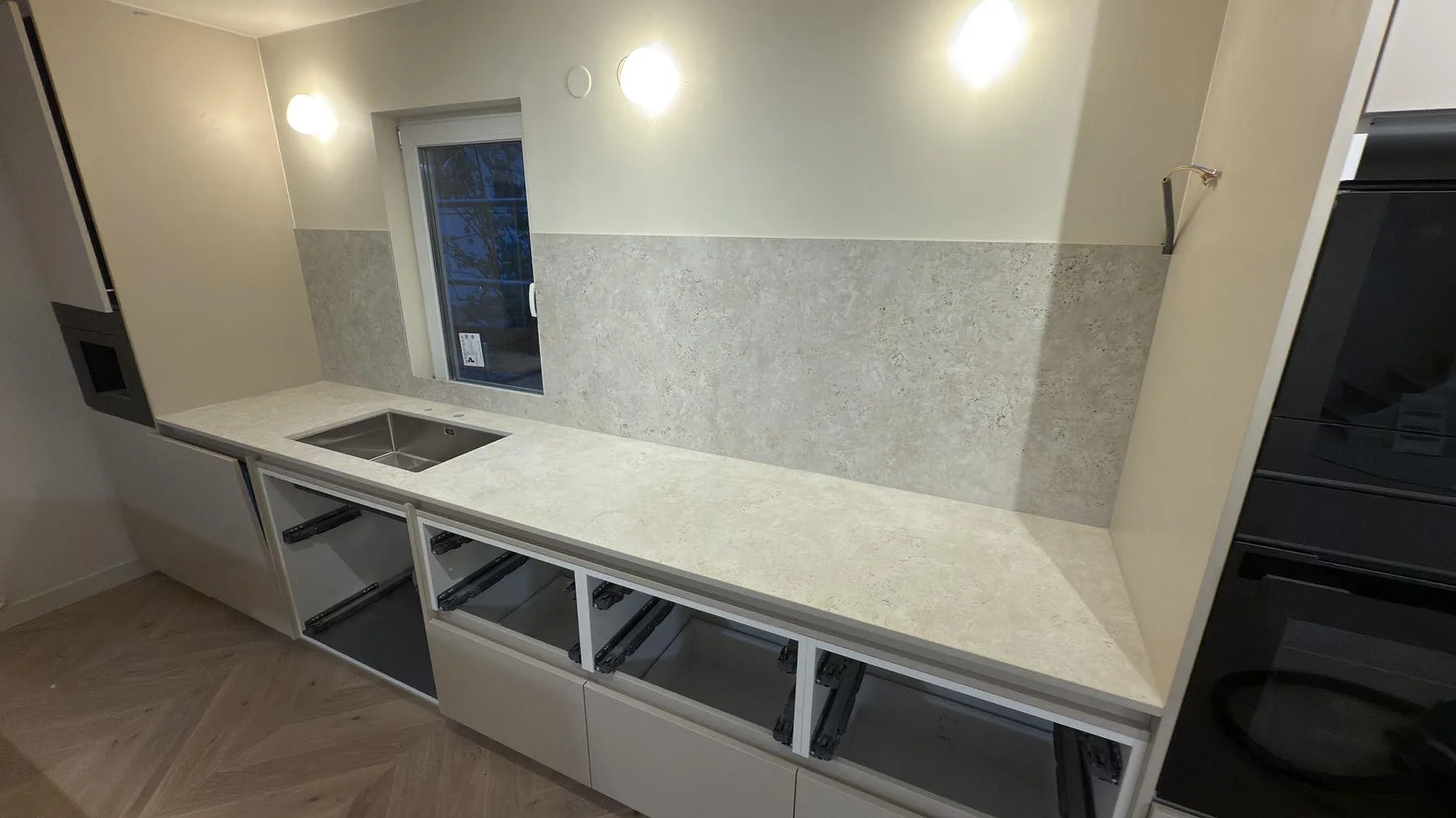 Rak köksbänk i matt Dekton Tk05 Sabbia med rostfri diskho och matchande stänkyta i keramik i Stockholm.
