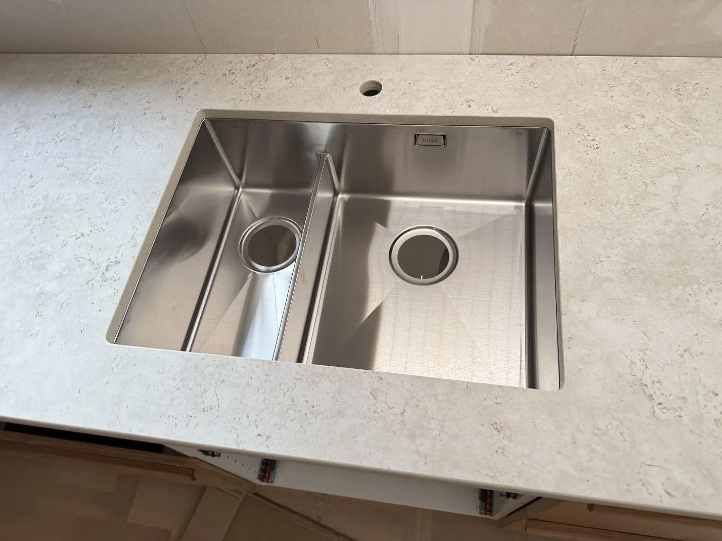Detalj av rostfri diskho i matt keramisk Dekton Tk05 Sabbia med blandarhål och ljus ådring i Tollered.