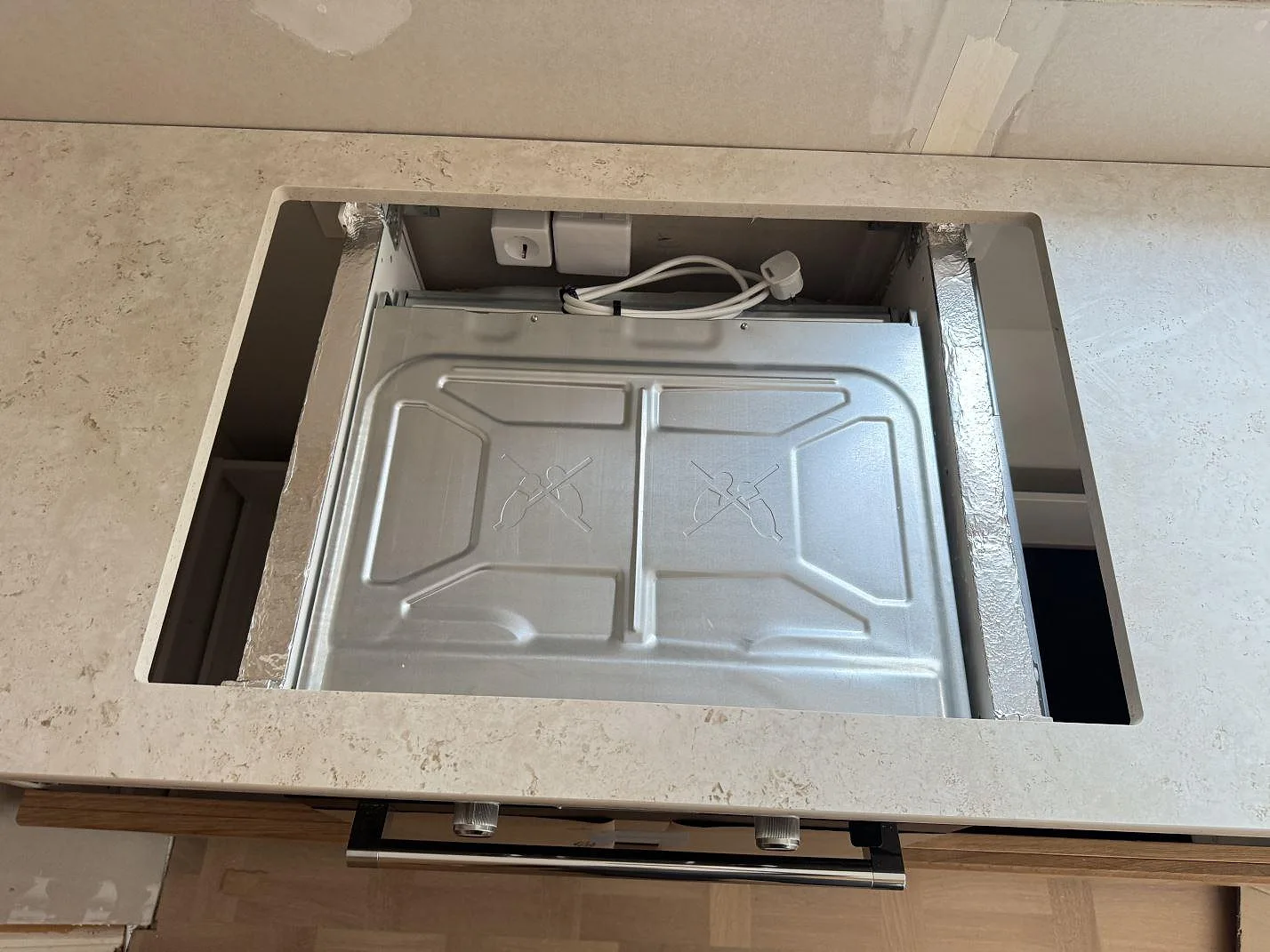 Hällöppning i matt keramisk Dekton Tk05 Sabbia med synlig stenprofil och pågående köksmontering i Tollered.