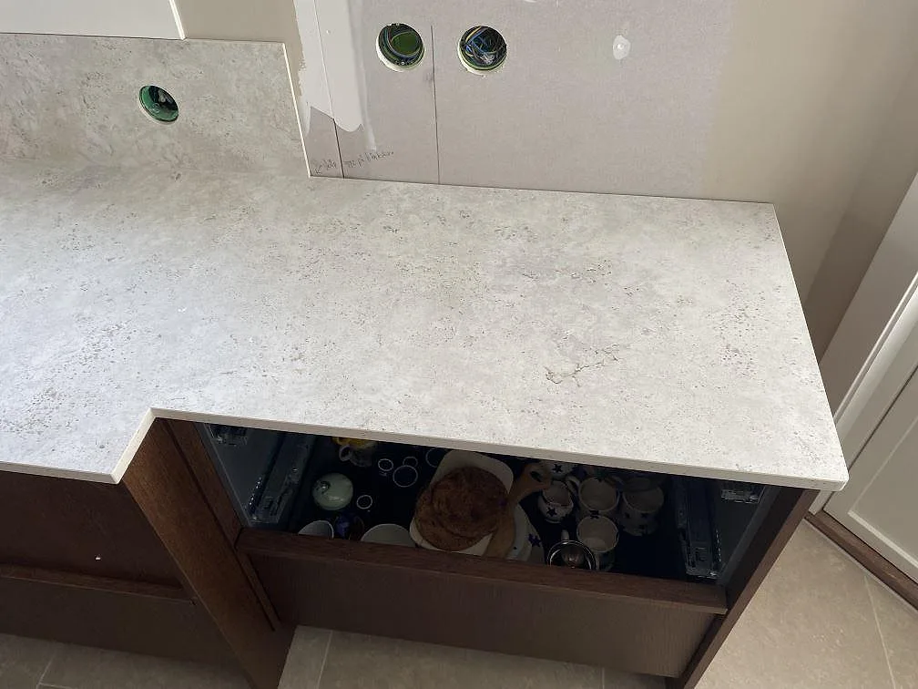 Rak köksbänkskiva i matt Dekton Tk05 Sabbia med ljusgrå struktur och stänkskydd i Väjern.