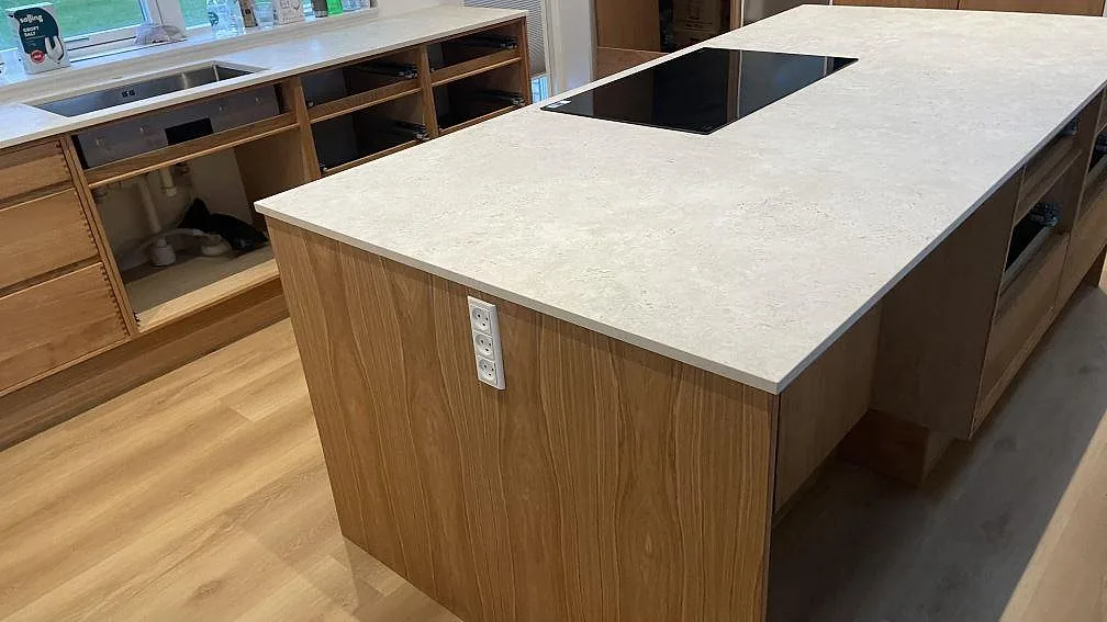 Matt Dekton Tk05 Sabbia på köksö med svart häll och bänkskiva vid diskhon i bakgrunden i Vejle.