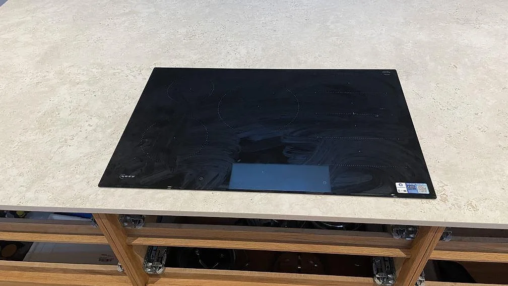 Detalj av svart häll på matt Dekton Tk05 Sabbia, med ljus stenstruktur synlig runt hällen i Vejle.