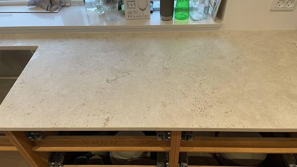 Närbild på matt Dekton Tk05 Sabbia vid diskhon, med ljus keramisk struktur och bänkskiva under fönster i Vejle.