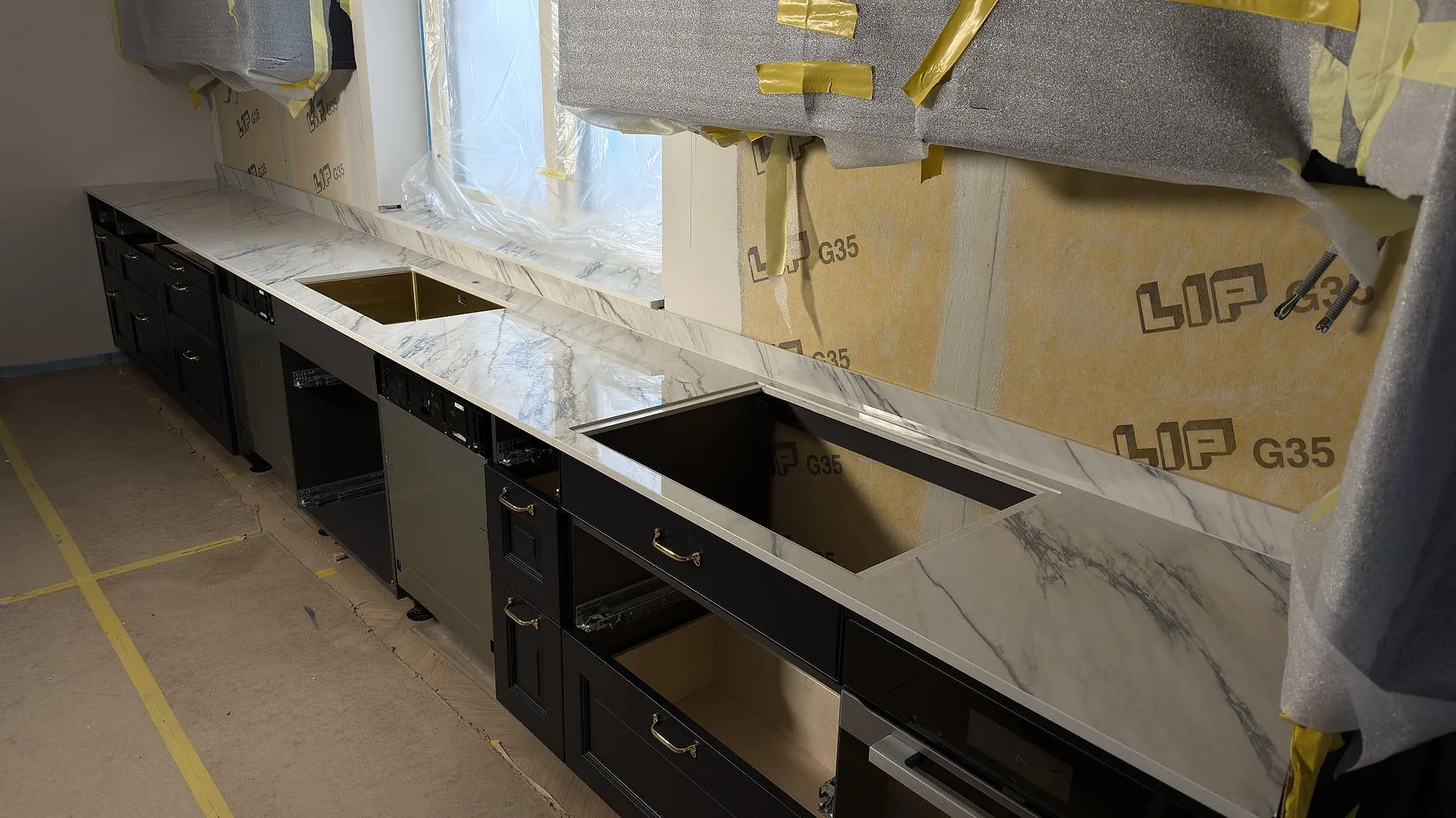 Polerad köksbänkskiva i Dekton Trance keramik med uppvikt stänkskydd, synlig diskho och öppning i arbetsytan i Åkersberga.