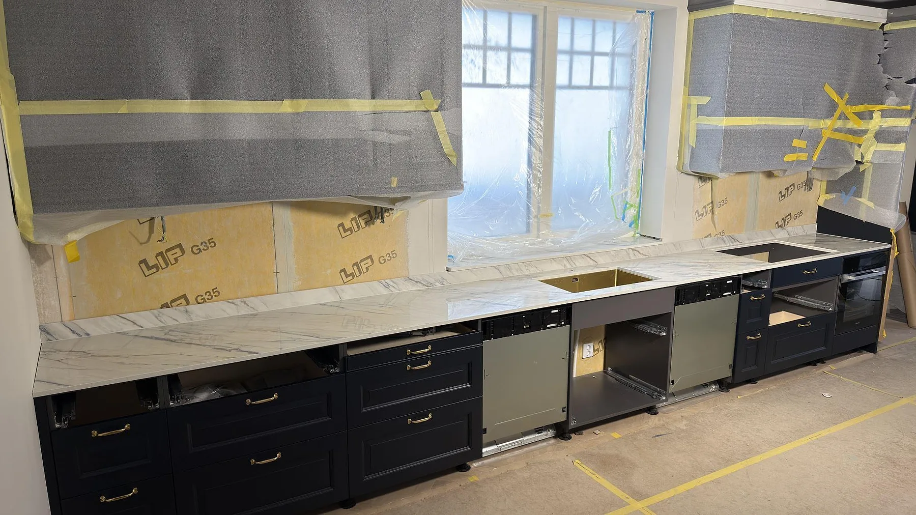 Köksbänkskiva i polerad Dekton Trance, keramisk yta med grå ådring, monterad längs en vägg i ett kök i Åkersberga.